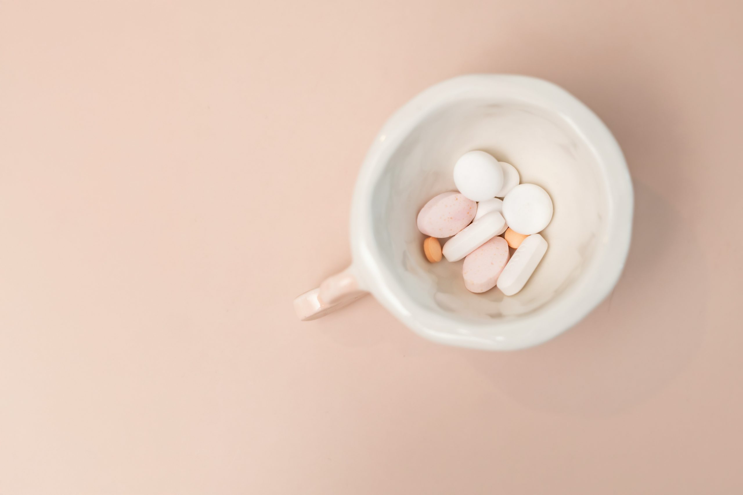 Morning coffee mug next to supplement capsules