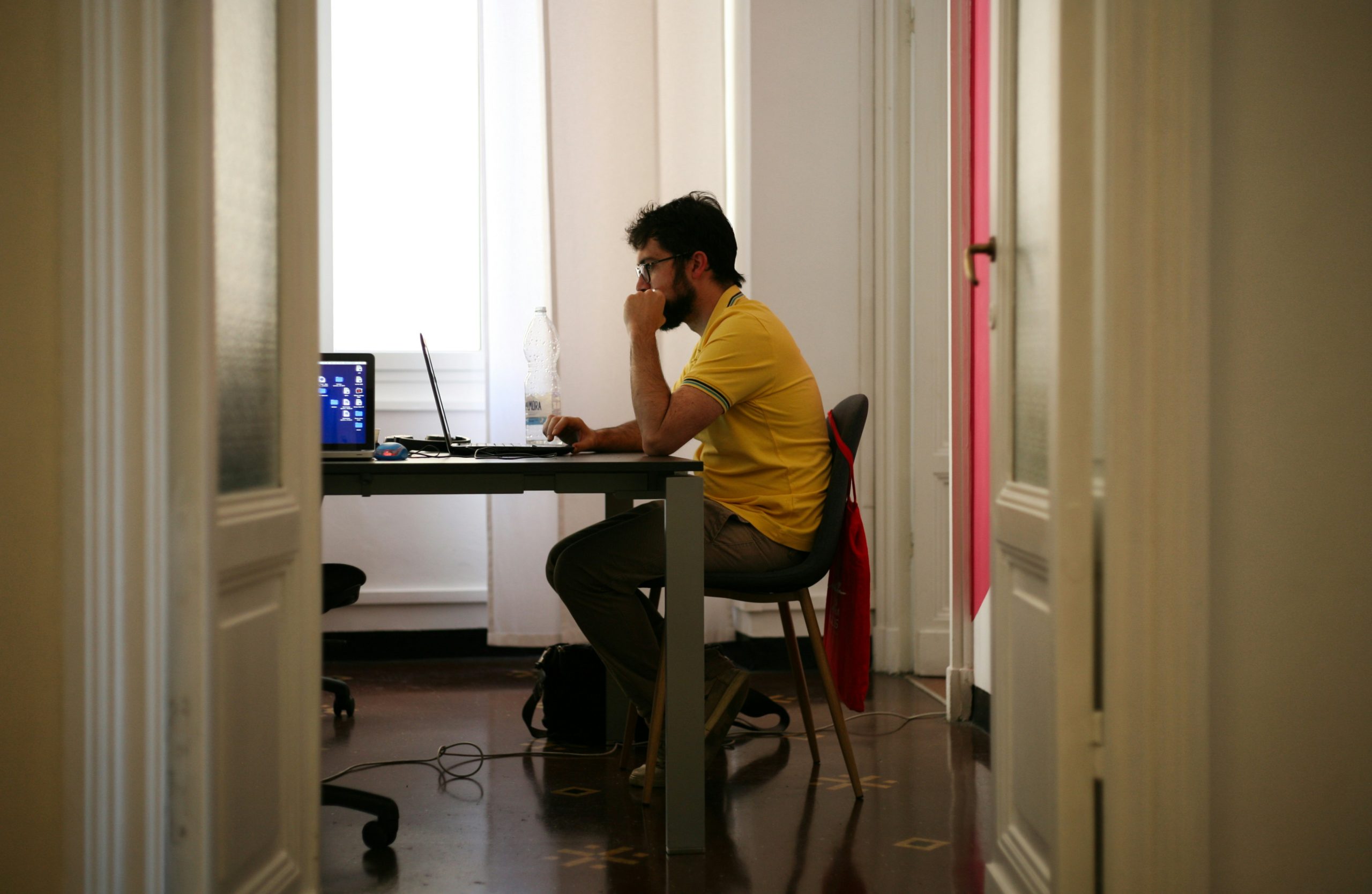 Man at a desk in a moment of reflection